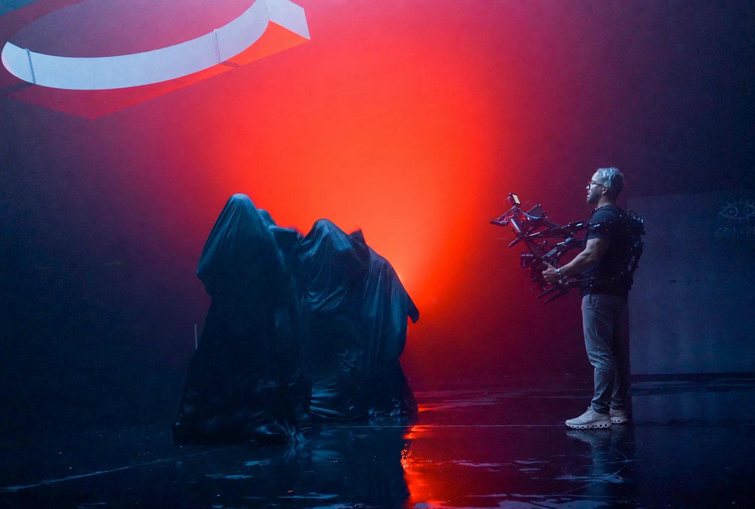 Camera operator on a film set with red and blue lighting